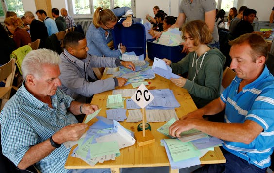 Leden van een stembureau in het Zwitserse Zürich tellen de stembiljetten.