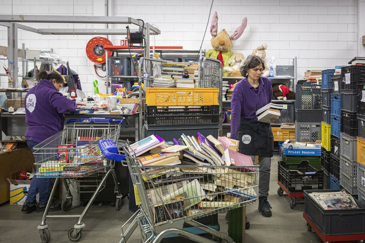 Medewerkers van Het Goed controleren en sorteren binnengekomen spullen in het magazijn in Zaandam.