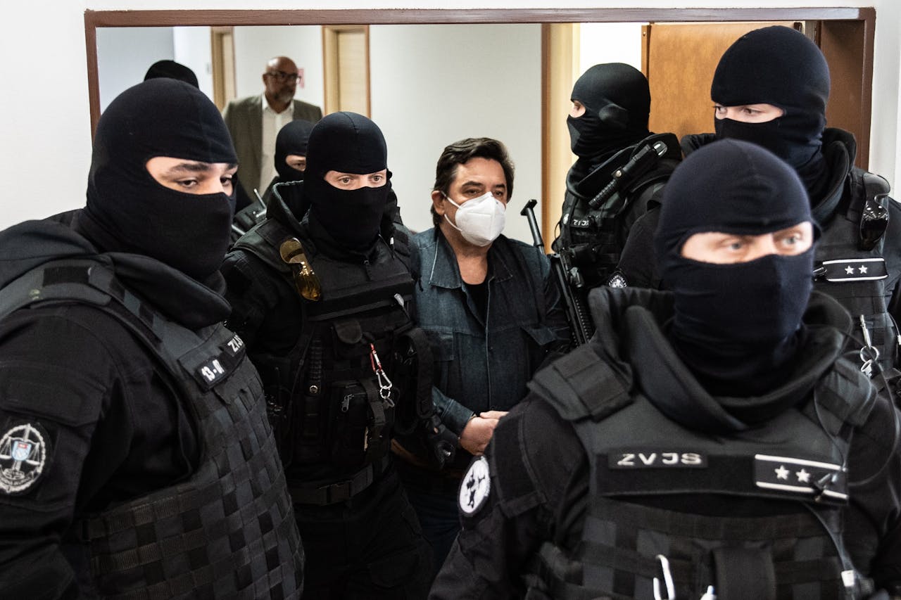 Gemaskerde agenten brengen de zakenman Marian Kocner (midden, met mondkapje) het gerechtsgebouw in Pezinok (ten noordoosten van Bratislava) binnen.