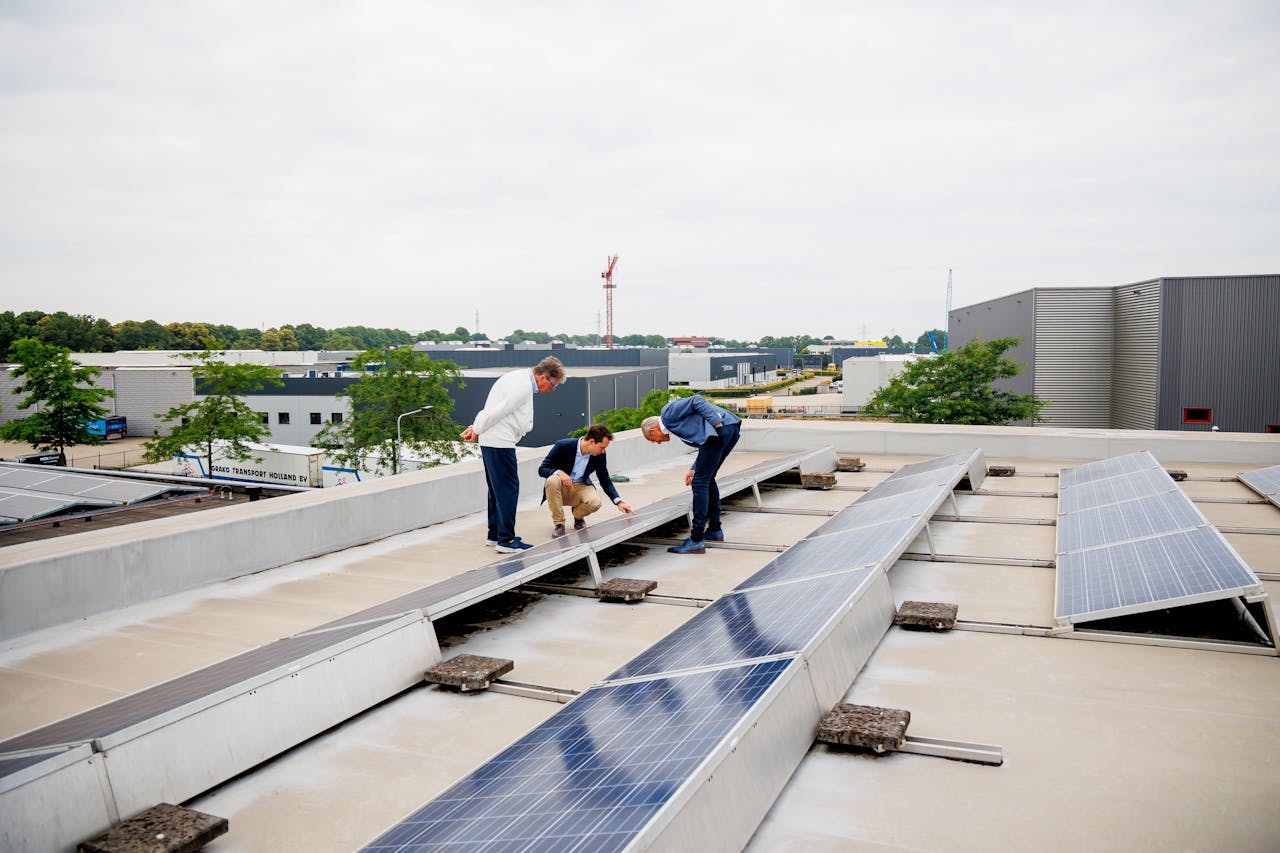 Wim Schilders (voorzitter Bedrijvenpark Pannenweg), Enzo Diependaal (projectleider) en Dick van Aggel (directeur Medicura) bekijken zonnepanelen op het dak van Medicura in Nederweert.