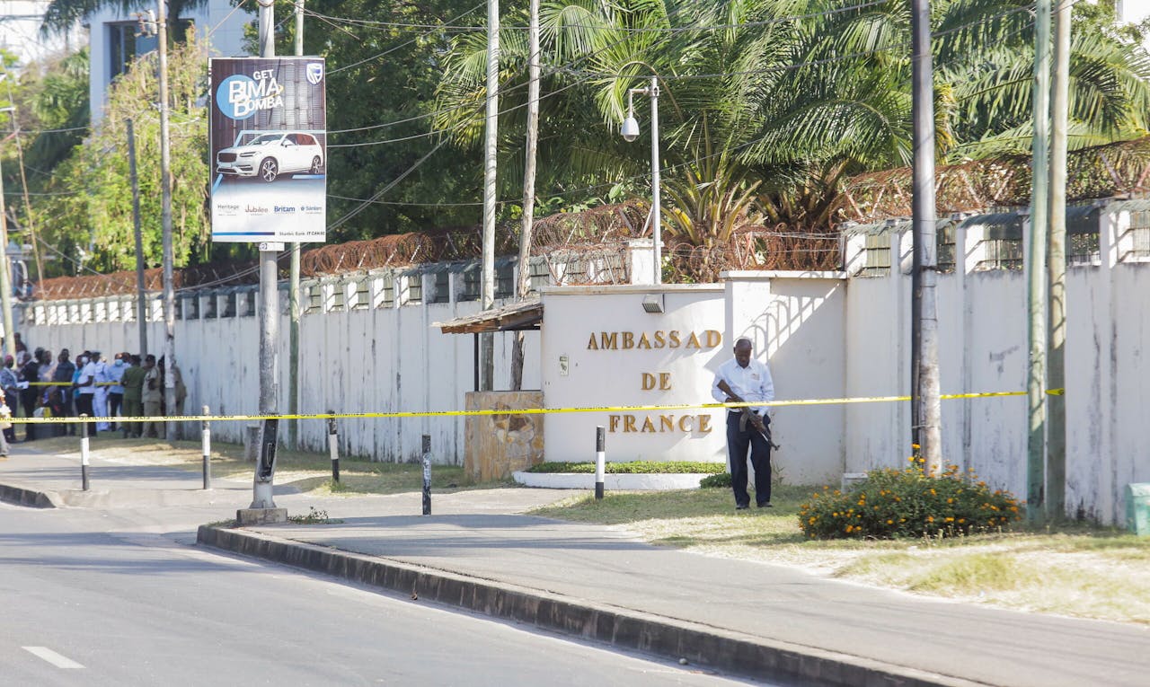 Een Tanzaniaanse veiligheidsbeambte bewaakt de toegang van de Franse ambassade in Dar es Salaam na de schietpartij van woensdag.
