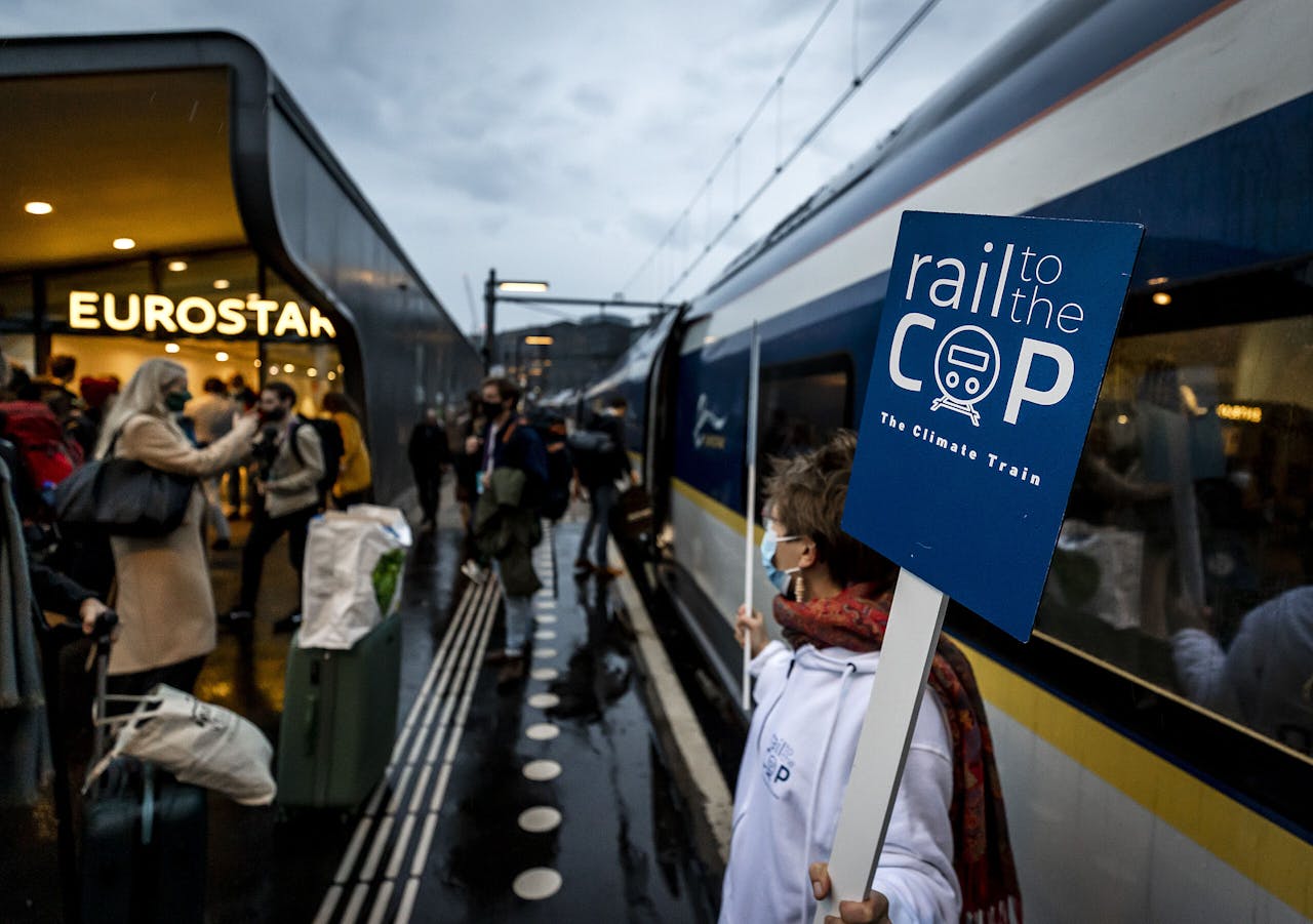 Passagiers stappen in de Klimaattoptrein, die vanaf Amsterdam Centraal via Rotterdam en Brussel naar Londen rijdt. Vanaf daar reisden de inzittenden met een andere trein door naar Glasgow, voor de jaarlijkse klimaatconferentie van de VN.