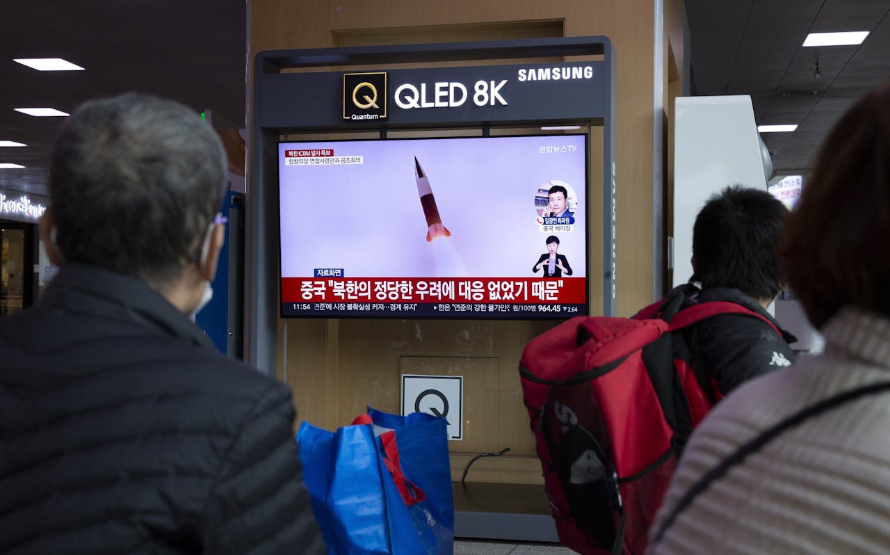 Zuid-Koreanen kijken op een scherm in een station in hoofdstad Seoul naar het nieuws dat Noord-Korea een intercontinentale ballistische raket (ICBM) heeft gelanceerd.