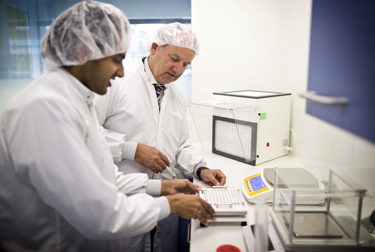 Lebbink en assistent (links) behoort met zijn Transvaal Apotheek inmiddels tot de minderheid van apothekers die nog in staat is zelf medicijnen te bereiden.