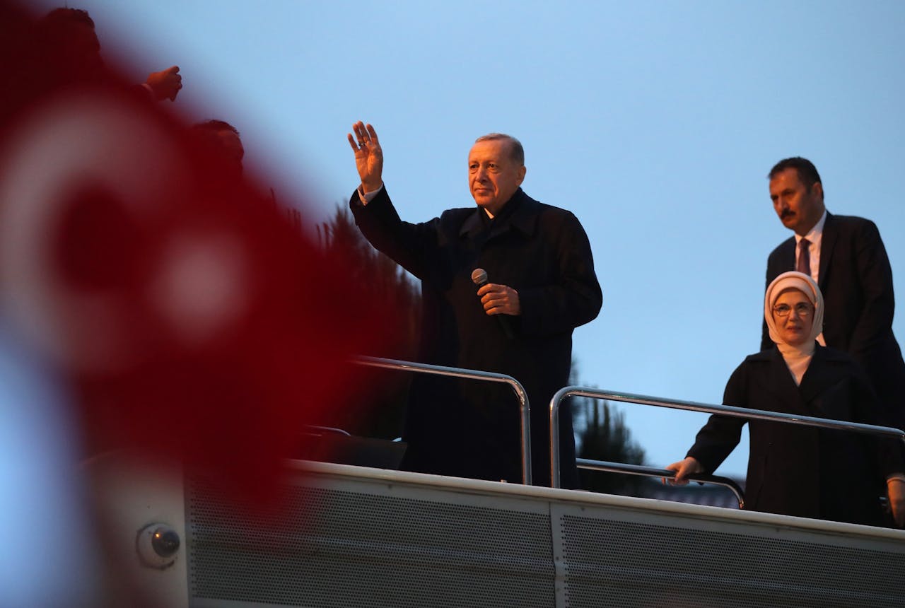 De Turkse president Erdogan zwaait naar aanhangers vanaf een bus nadat hij de overwinning heeft geclaimd.
