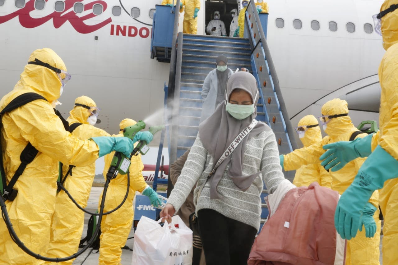 Indonesiërs afkomstig uit Wuhan worden begin februari met een desinfecterende vloeistof bespoten bij terugkeer in Batam, Indonesië.