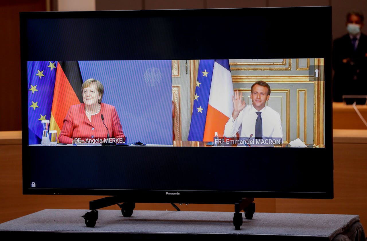 Angela Merkel en Emmanuel Macron op een scherm tijdens een videomeeting met de voorzitter van de Europese Raad Charles Michel, voorafgaand aan de EU-top in Brussel.