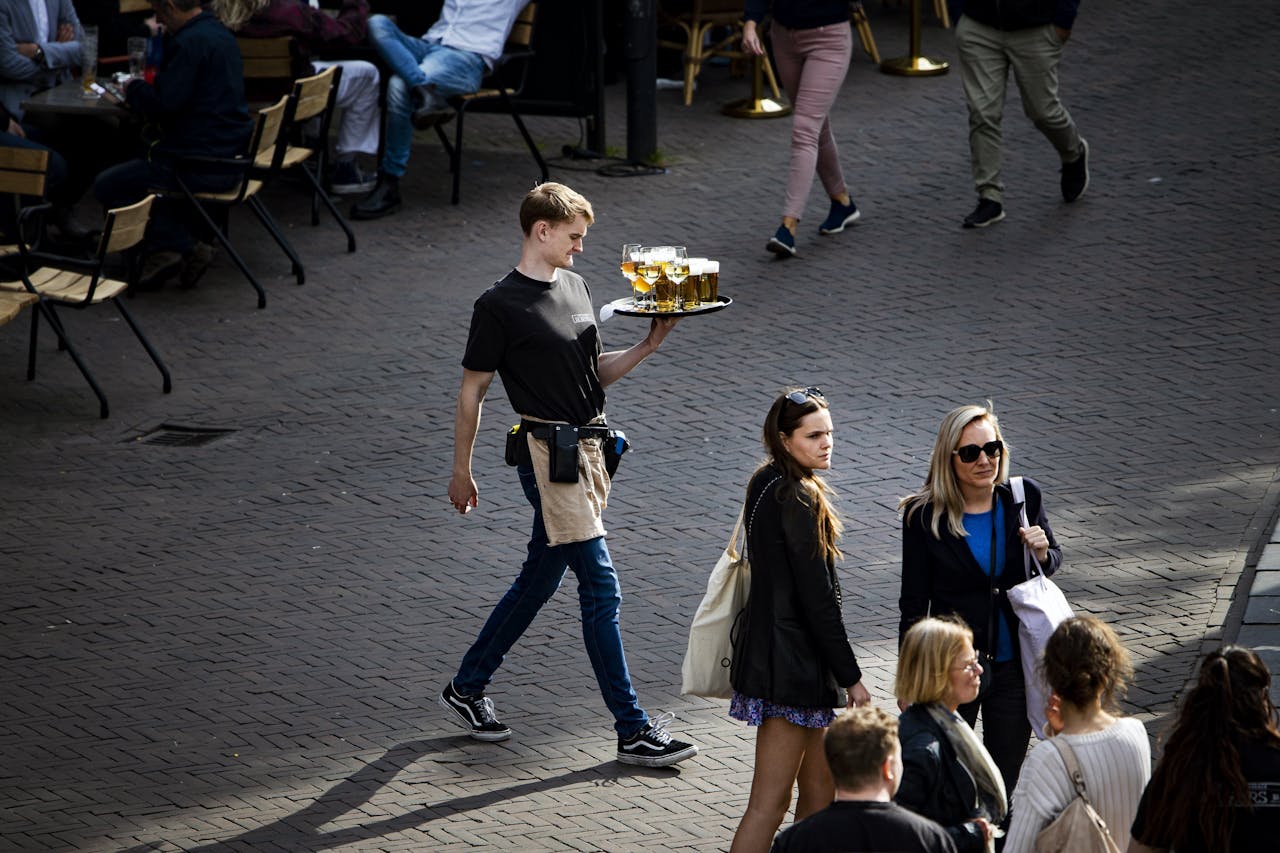 Een ober loopt over het plein in de Utrechtse binnenstad.