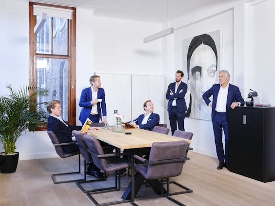 Patrick Munk (zittend in het midden), medeoprichter van het kantoor Vesper met zijn collega’s aan de Westermarkt. ‘Wij hebben niets met de stoffige kantooromgeving van de Zuidas.’