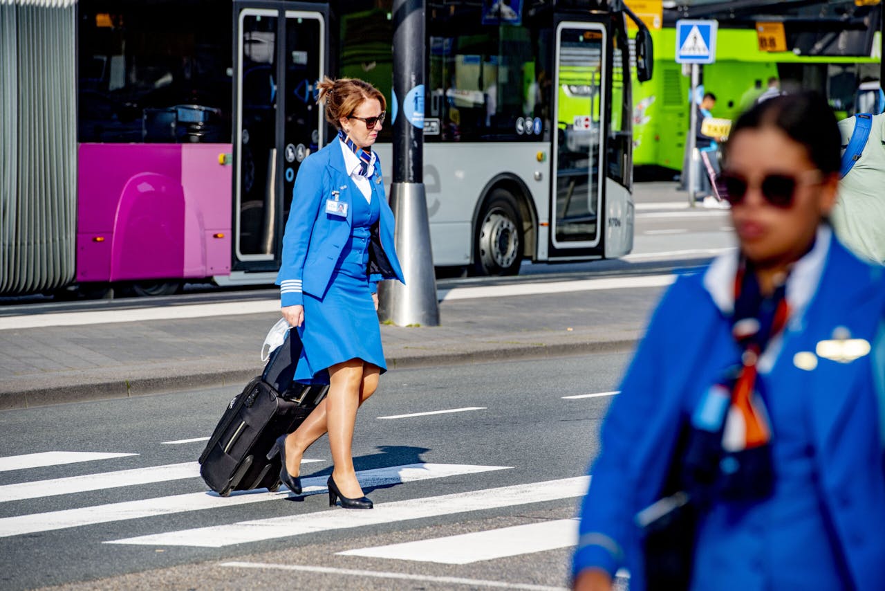 KLM-stewardessen op weg naar Schiphol. Tijdens de zomervakantie leek er sprake van herstel. Maar met het groeiend aantal reisbeperkingen staan er weer meer toestellen aan de grond.