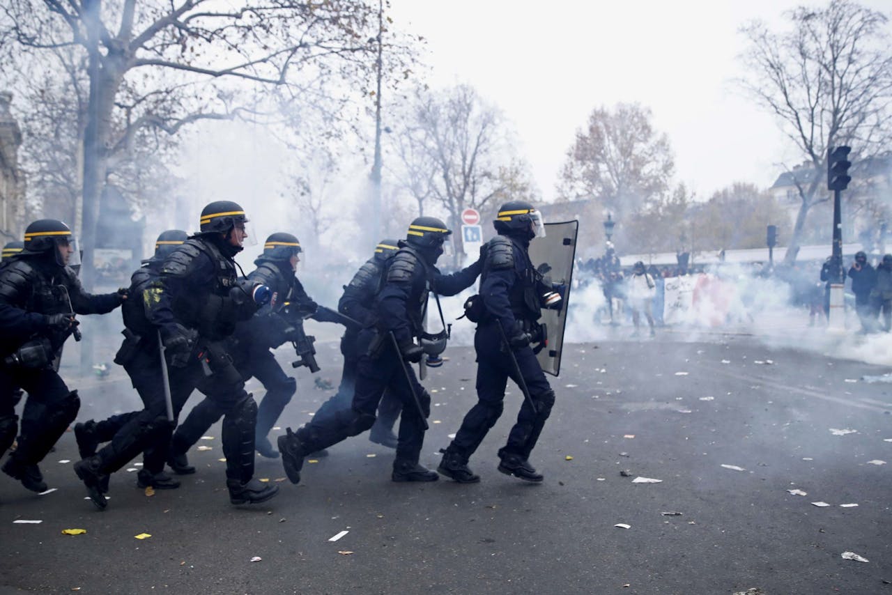 De Franse oproerpolitie in een charge met demonstranten in Parijs tegen de plannen om het Franse pensioenstelsel te hervormen.