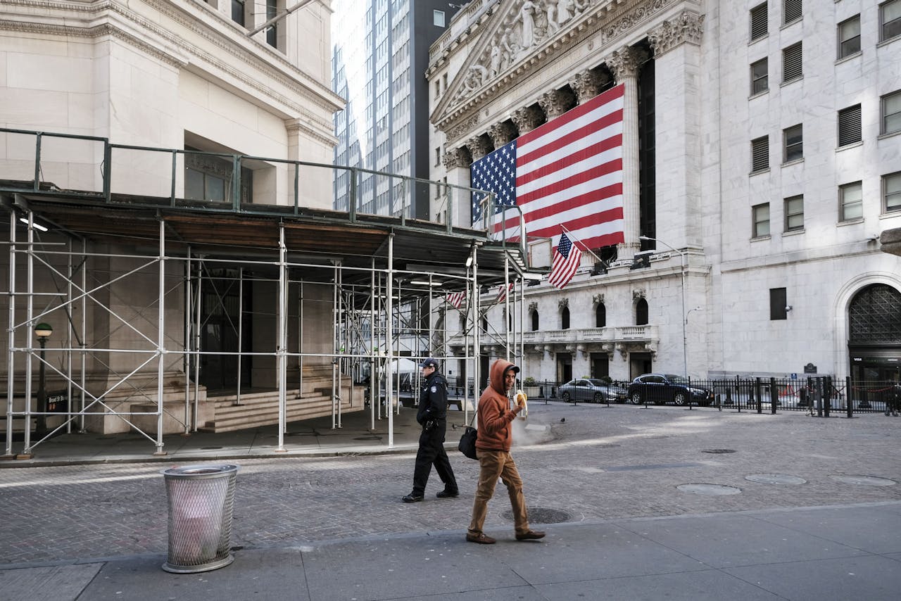 Een voorbijganger loopt langs een verlaten Wall Street.