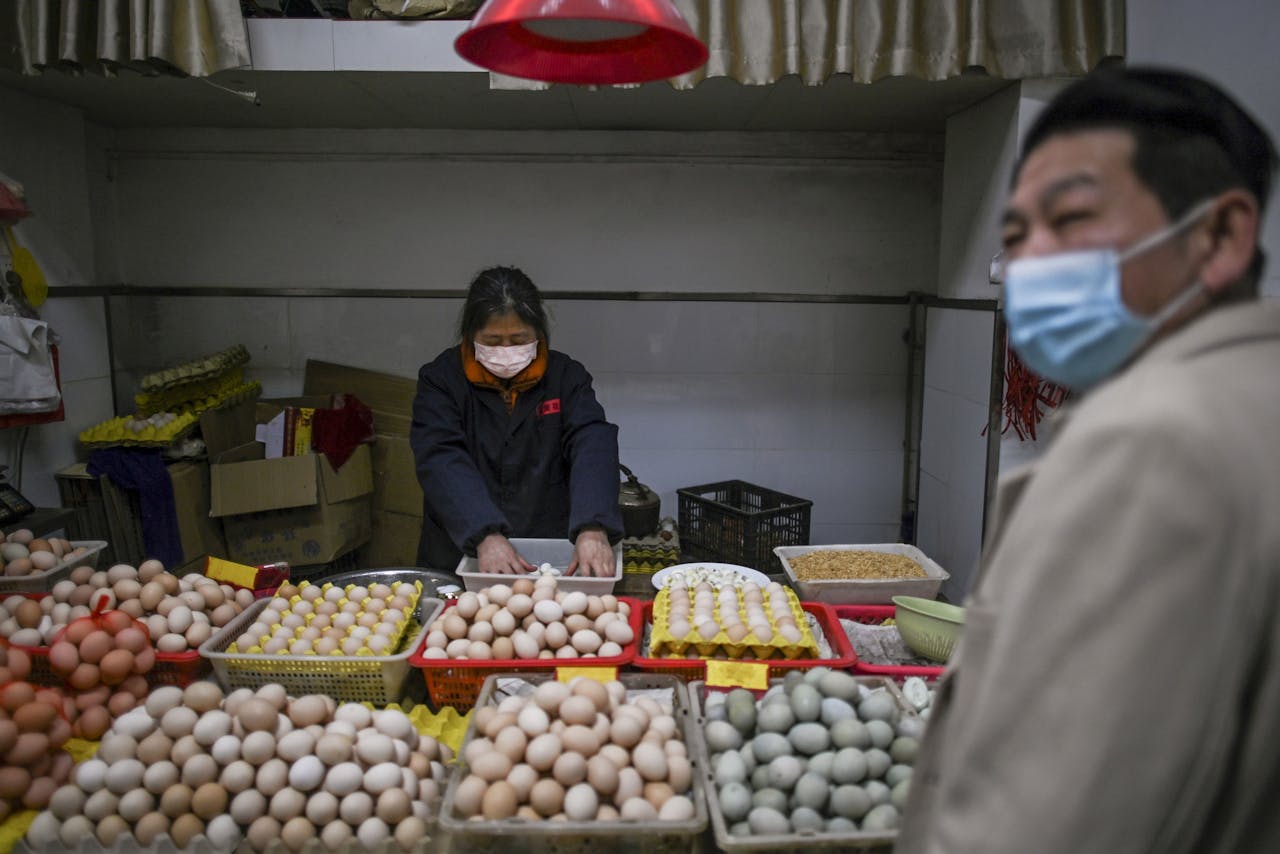 Een eierverkoopster in Wuhan bedient bij haar marktkraam een klant. In de Chinese stad waar het coronavirus het eerst aan de oppervlakte kwam, gaan de deuren weer langzaam open.
