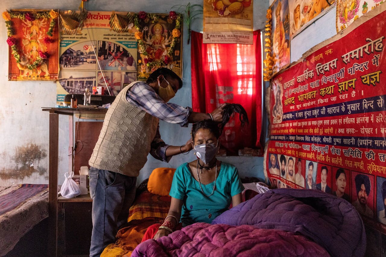 Suresh Kumar bindt het haar van zijn vrouw Pramila Devi samen voordat ze naar de geïmproviseerde kliniek in hun dorp vertrekken.