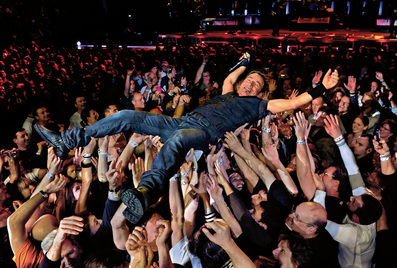 Bij popmuziek gaat het niet om het persoonlijke, maar om het gedeelde. Springsteen aan het crowdsurfen tijdens een concert in Baltimore in 2009. (Foto: Michael Williamson / The Washington Post / Getty Images)