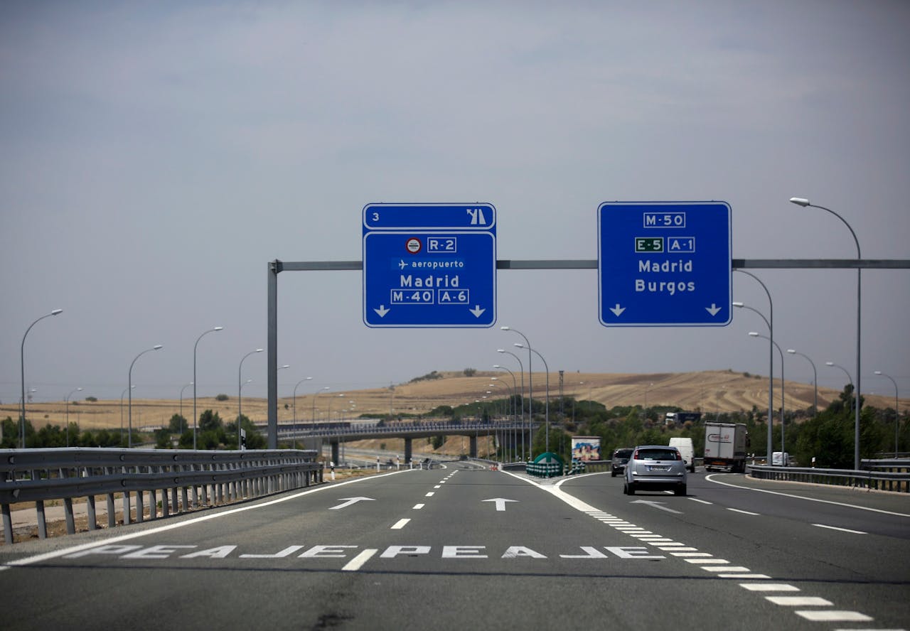 Auto's nemen de afslag naar de gratis snelweg richting Madrid. De tolweg naar de Spaanse hoofdstad is verlaten. foto: Reuters