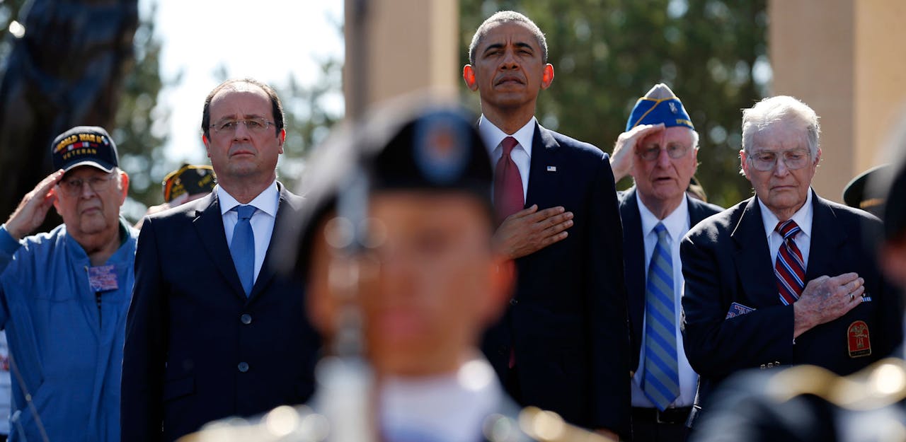 De Amerikaanse president Barack Obama (3e van rechts) en zijn Franse collega François Hollande (2e van links) herdenken D-Day in aanwezigheid van Britse en Franse oorlogsveteranen in Colleville-sur-Mer.