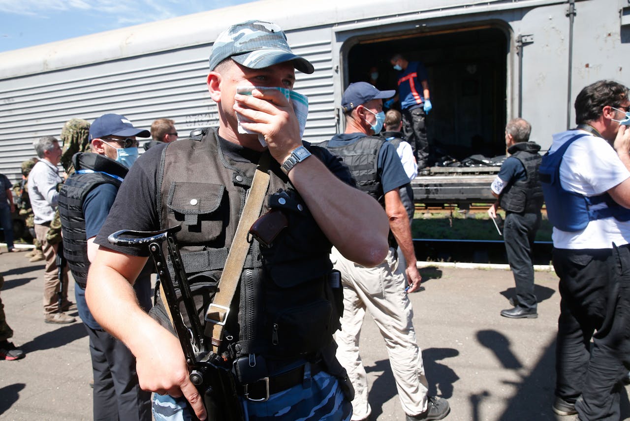 Leden van de OVSE en een Nederlands forensisch onderzoeksteam inspecteren de stoffelijke overschotten van de slachtoffers van de vliegramp in Oekraine in een trein op het station van Torez.