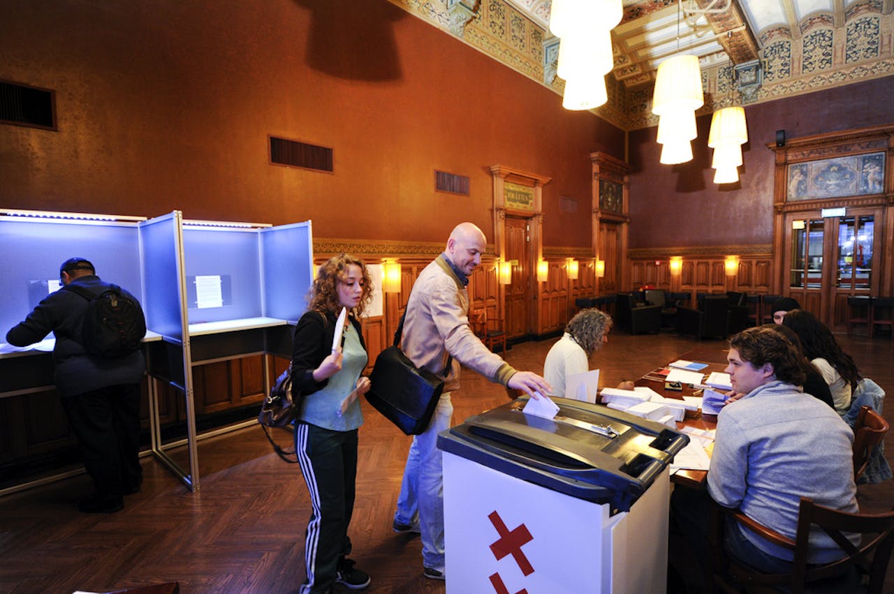 De eerste kiezers melden zich 's ochtends vroeg in het stembureau in de restauratie van station Amsterdam Centraal. Op een aantal stations kunnen reizigers vanaf 06.30 hun stem uitbrengen.