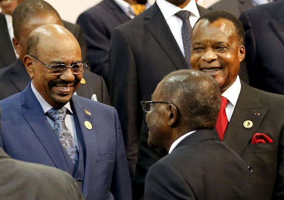 De Soedanese president Omar al-Bashir (links) wordt zondag begroet door de president van Zimbabwe Robert Mugabe tijdens een bijeenkomst van de Afrikaanse Unie in Zuid-Afrika. Rechts de president van de Republiek Congo Denis Sassou Nguesso.