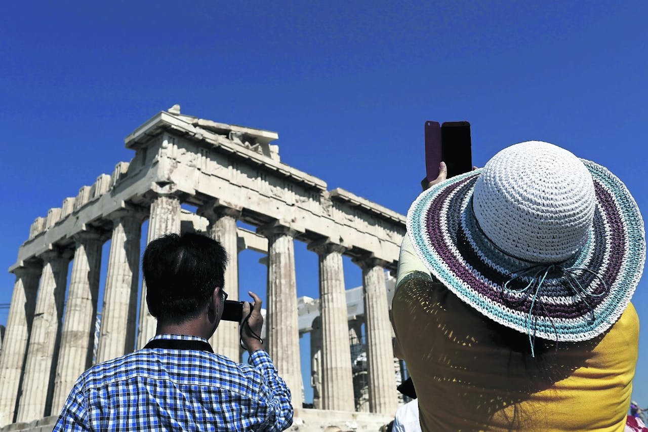 Toeristen bij het Parthenon op de Acropolis in Athene. ‘Iedere verspeelde dag is er nu een te veel’, zegt Themis Themistocleous.