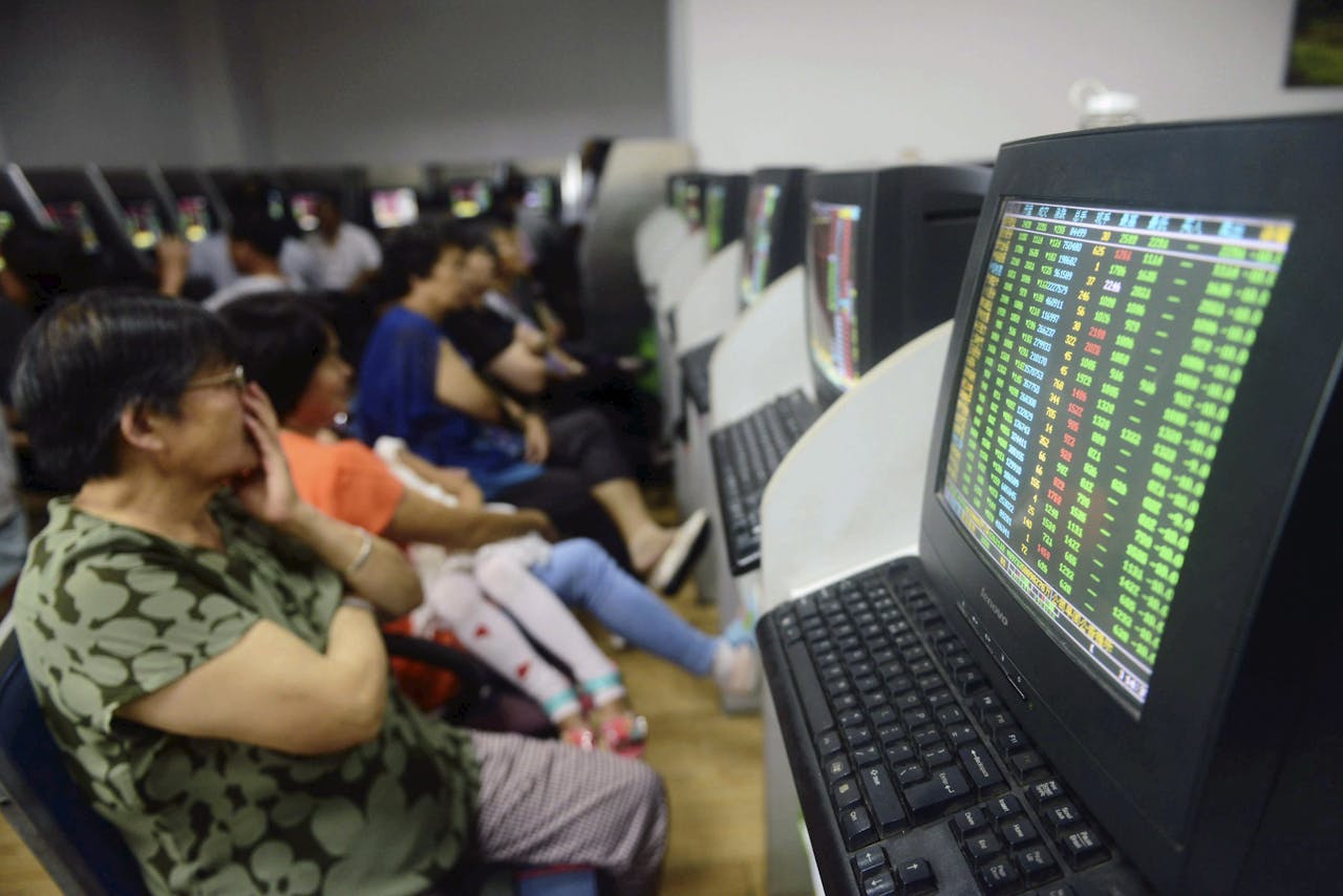 Chinese investeerders kijken gespannen naar een scherm met beurskoersen in Qingdao (foto: China Stringer Network/ Reuters).