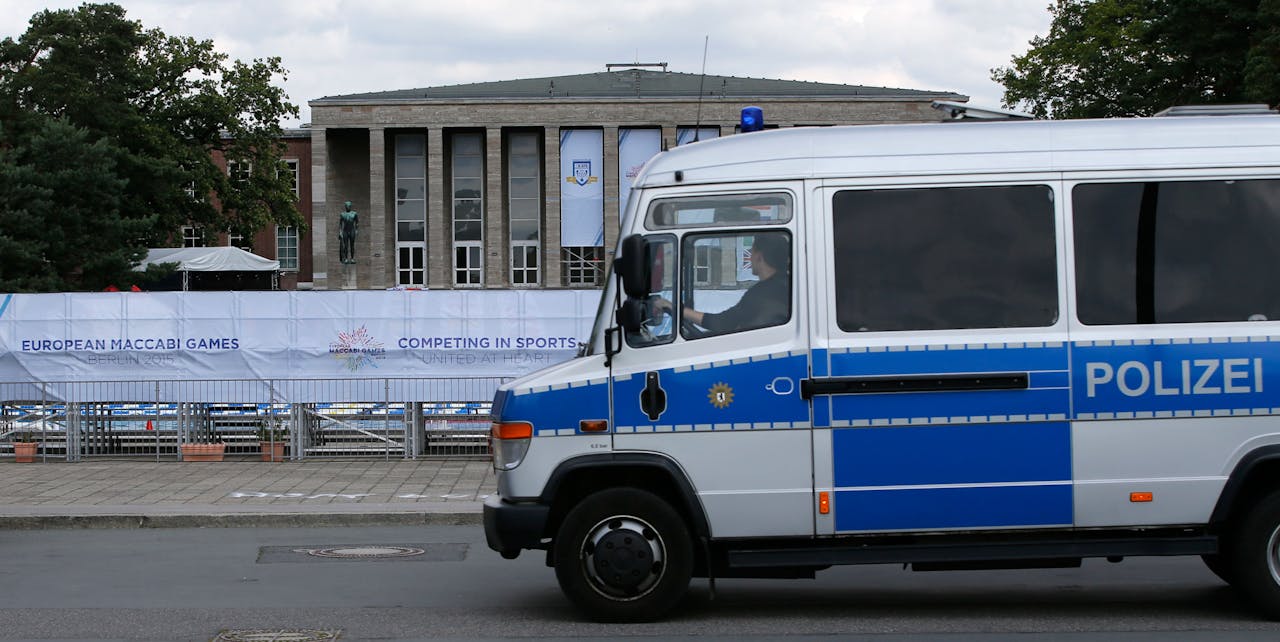 Een politieauto rijdt maandag langs een van de locaties van de 14de European Maccabi Games in Berlijn. Joodse atleten uit Europa komen tot en met 5 augustus bij elkaar om te sporten. Het is voor het eerst dat de spelen in Duitsland worden georganiseerd.