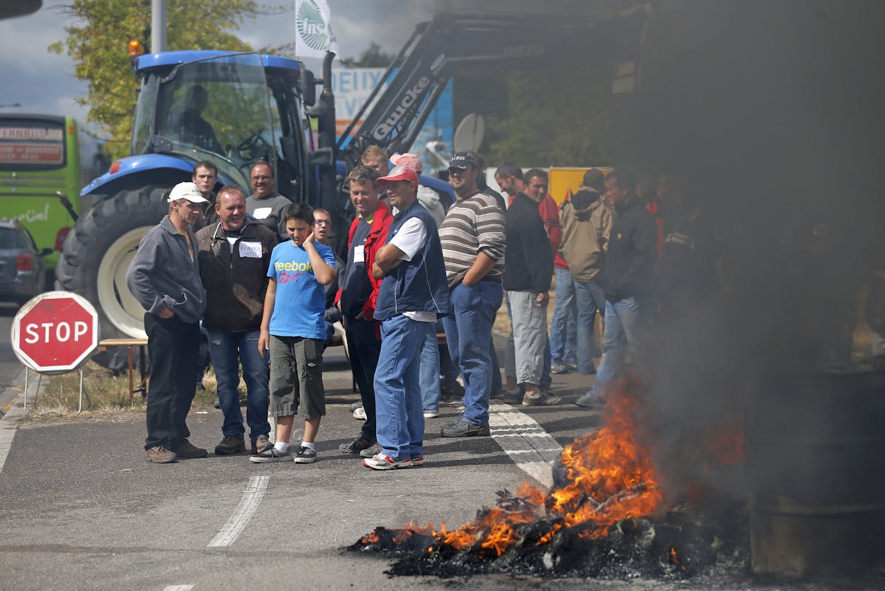 Franse veeboeren gebruiken vuur om de weg te blokkeren bij Strasbourg (foto: REUTERS/Vincent Kessler).