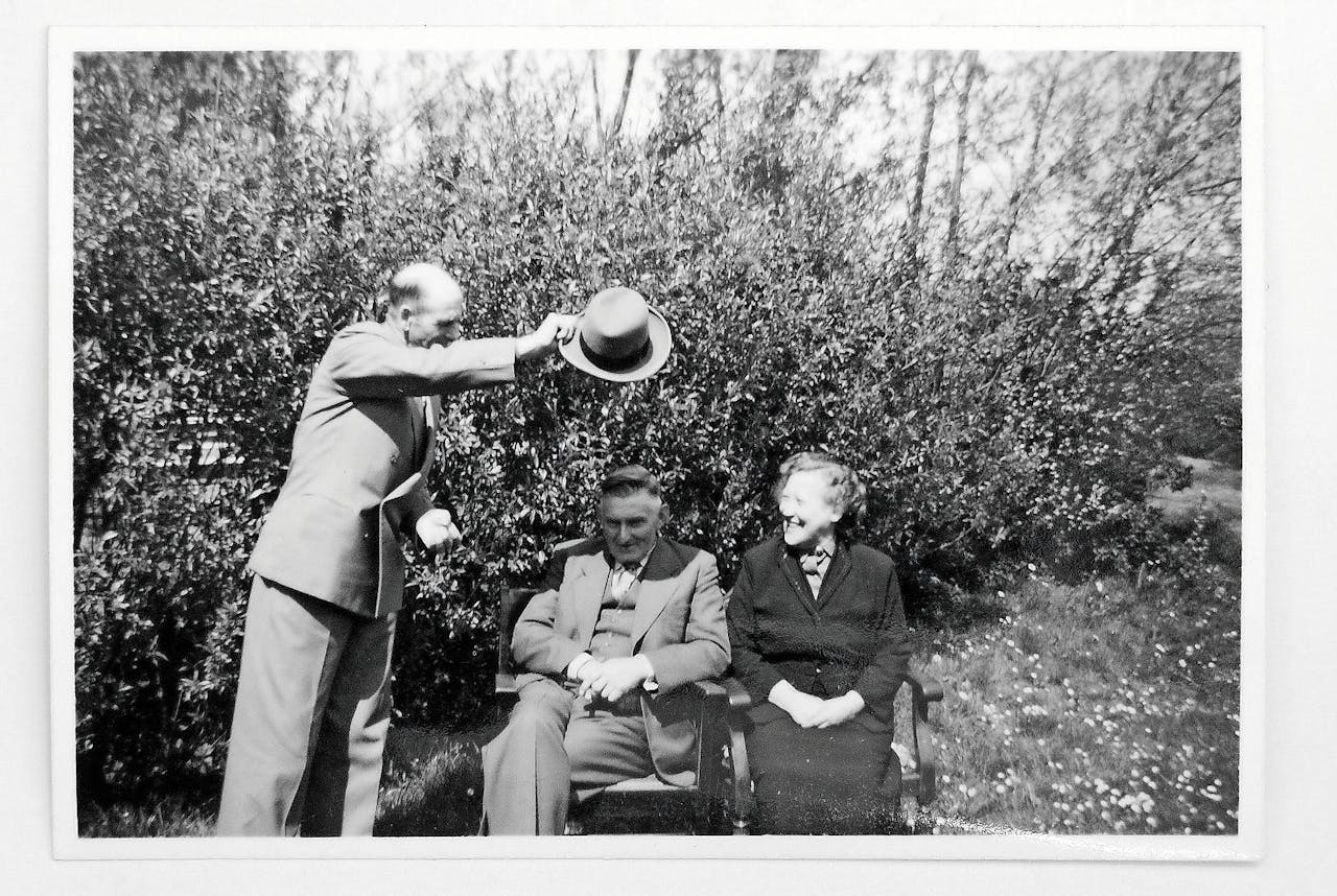 ‘Mijn ouders in de tuin op mijn vaders 53ste verjaardag in 1955. Hij kon niet tegen de zon in kijken; de vader van mijn schoonzus schiet te hulp.’