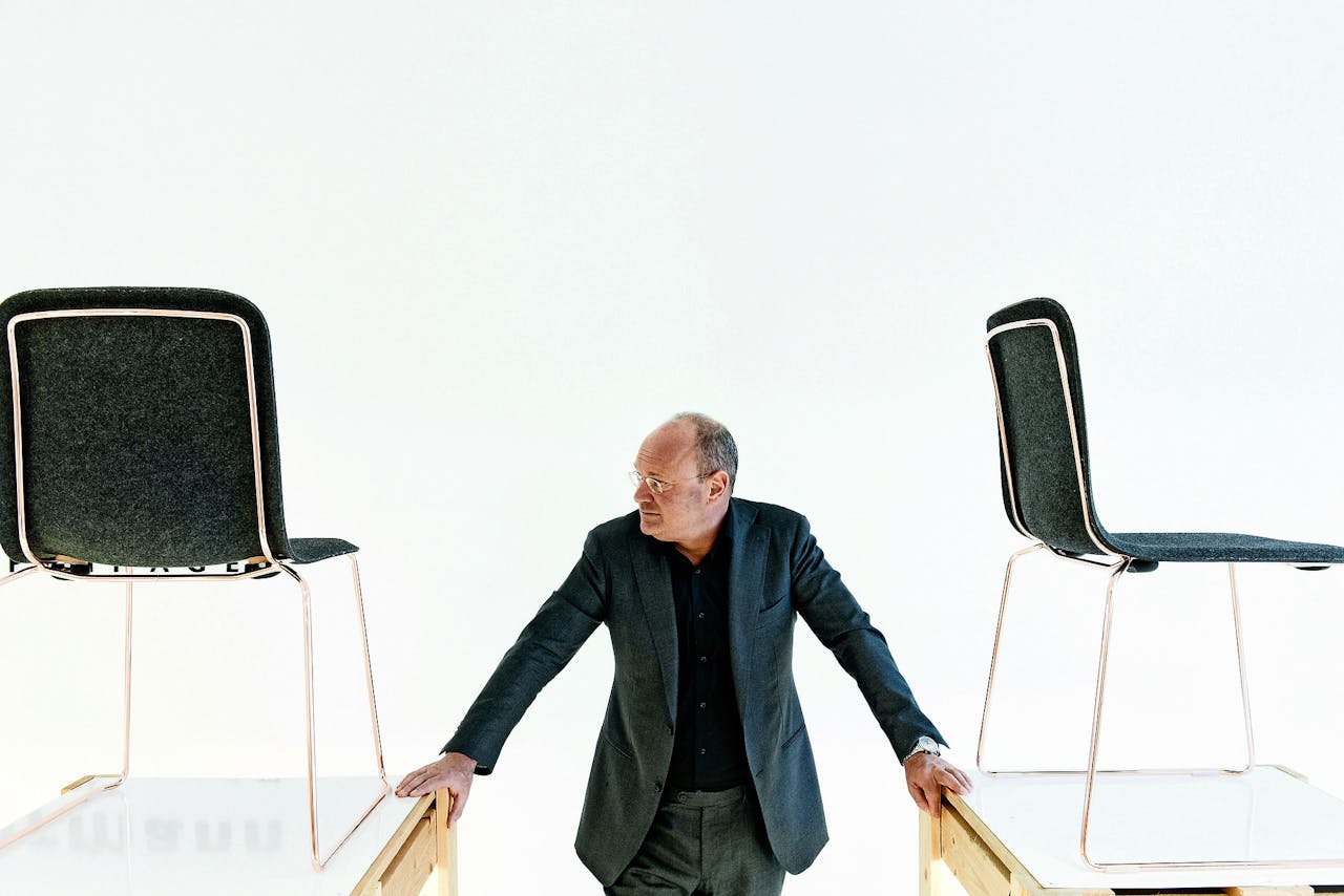 Hans Lensvelt tussen twee exemplaren van ‘This Chair Felt’, een stapelbare vilten stoel met stalen frame van ontwerper Richard Hutten.
