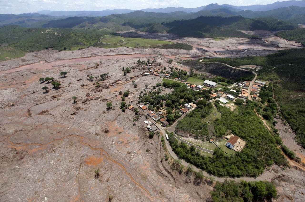 Het Braziliaanse dorp Bento Rodrigues na de dijkdoorbraak van vorige week waarbij een bassin met afvalwater bij een ijzerertsmijn van mijnbouwbedrijven BHP Billiton en Vale overstroomde. Er zijn 6 slachtoffers geborgen en 22 inwoners van het dorp worden nog vermist na de modderstroom. Dinsdag hebben activisten opgeroepen om de mijnen strenger te controleren. (Foto: Reuters)