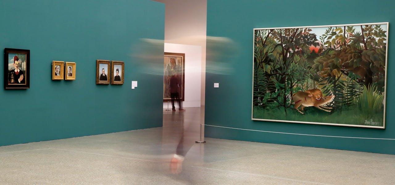 Overzicht van expositie in Essen. Rechts: ‘De hongerige leeuw stort zich op de antilope’ (1905) van Henri Rousseau, een beroemde autodidact. Geheel links zijn portret van ‘Monsieur X’ (1905-1906).