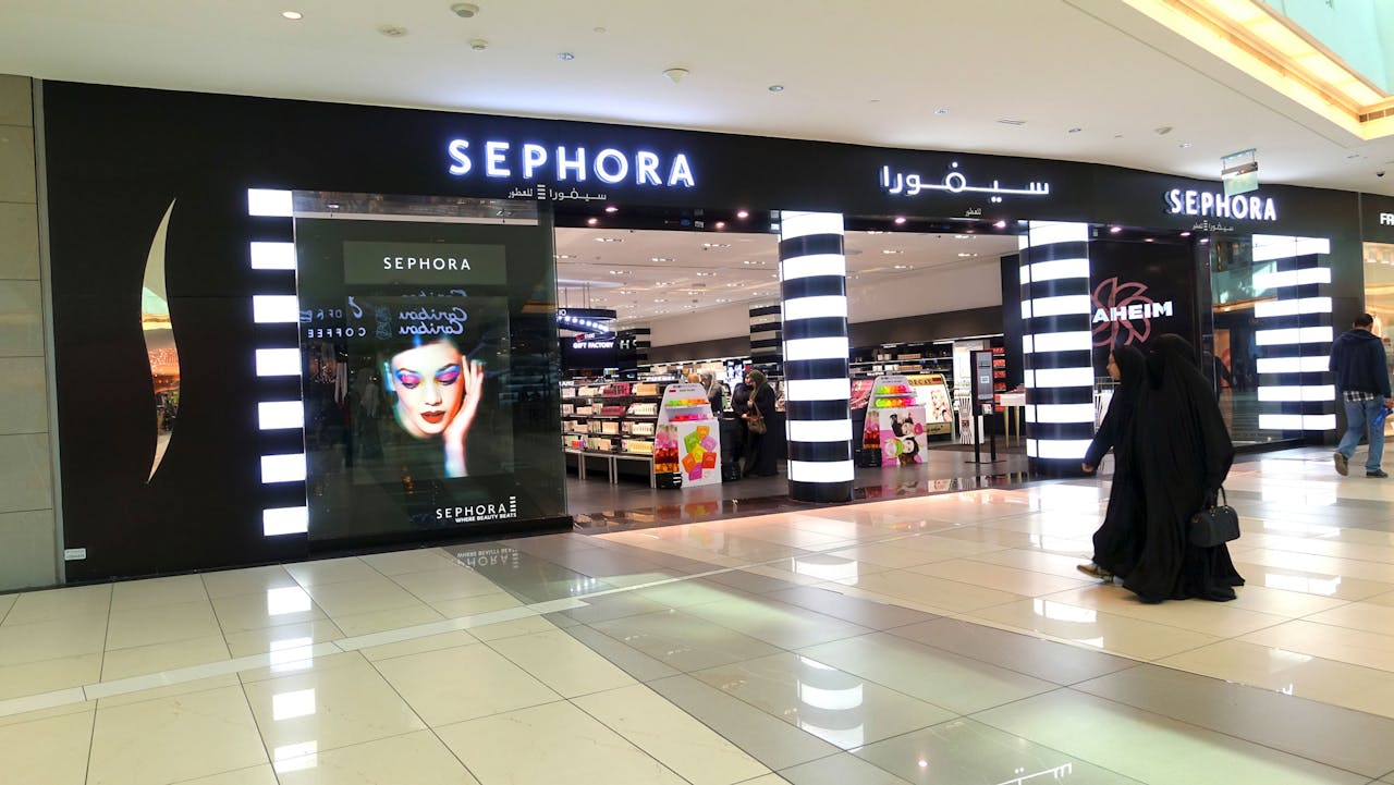 Gesluierde vrouwen in een Koeweits winkelcentrum passeren een vestiging van het Franse cosmeticaconcern Sephora. Het onderdeel van luxewarenconcern LVMH is van plan om dit jaar ook winkels in Iran te openen. Dat is mogelijk nu de sancties tegen dat land zijn opgeheven. (Reuters)