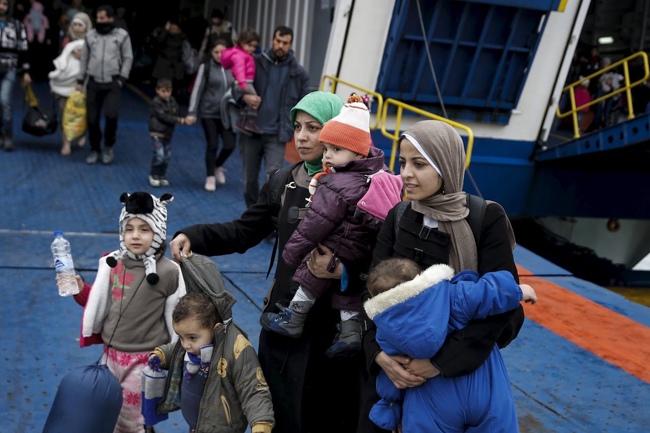 Syrische vluchtelingen verlaten een passagiersschip in de haven van Piraeus. foto: Reuters