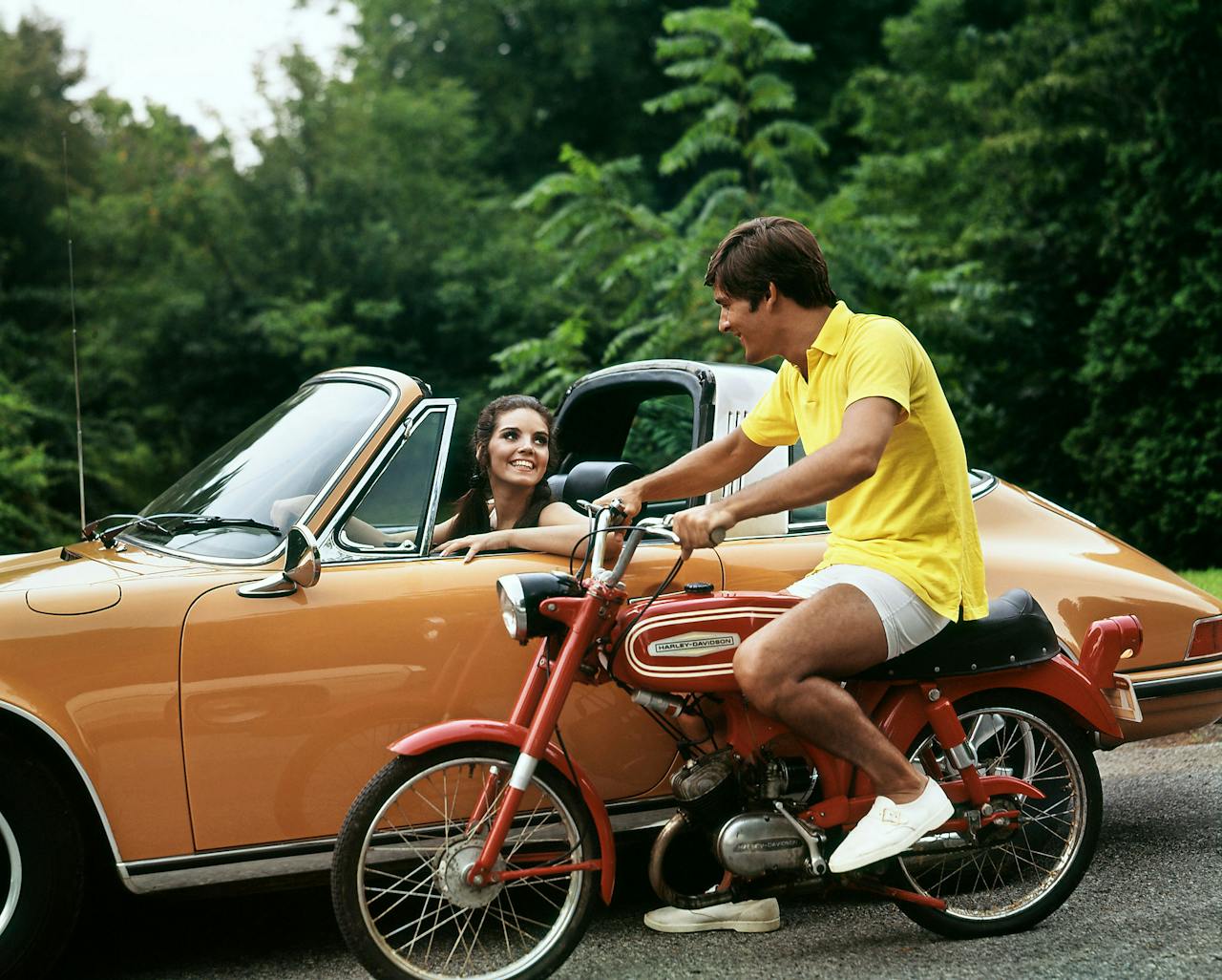 Lifestyle in de jaren '70. De man op een Harley Davidson motor en de vrouw in een Porsche. (Foto: Corbis/HH)