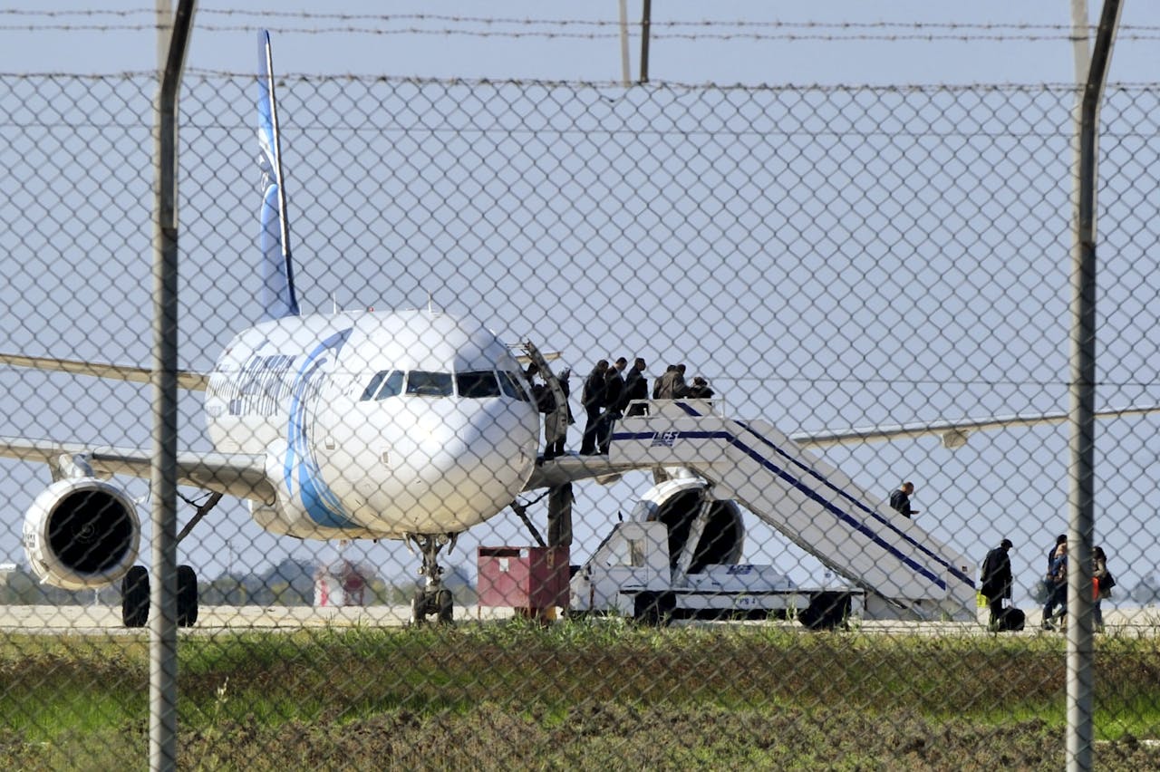 Passagiers verlaten het gekaapte toestel van Egypt Air. foto: Reuters