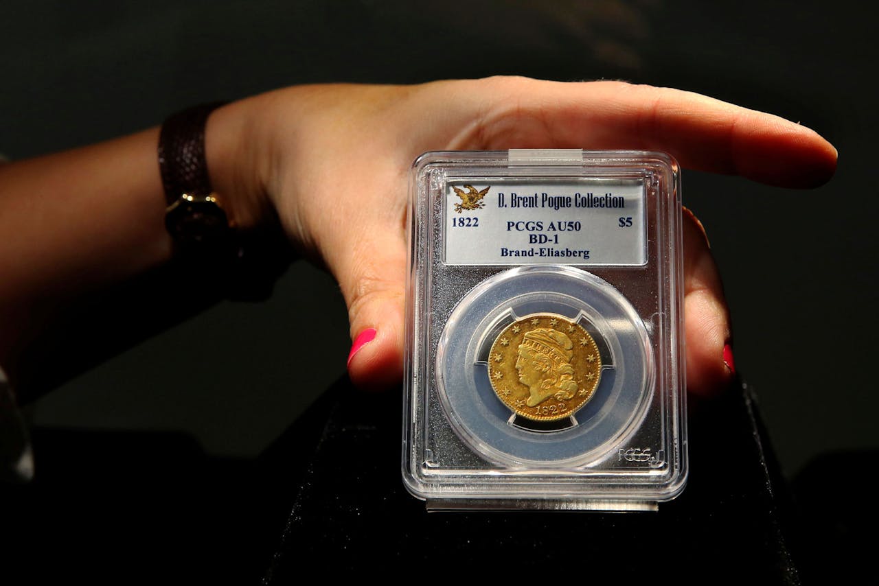 Een medewerker van veilinghuis Sotheby's toont een gouden vijfdollarmunt uit 1822. De munt, een 'half eagle' genoemd, maakt deel uit van de zogeheten D. Brent Pogue collectie en gaat dinsdag in New York onder de hamer. (Foto: Reuters)