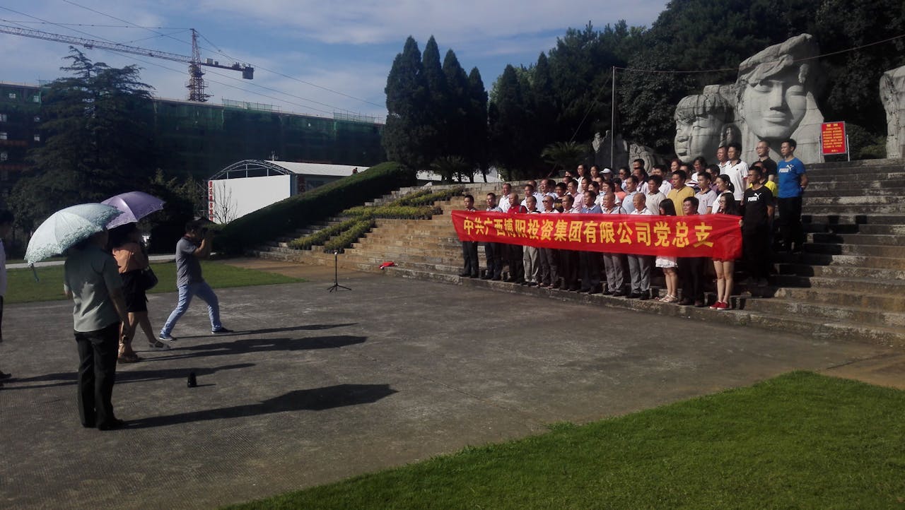 Medewerkers van investeringsmaatschappij Guangxi Bu Yang poseren voor een foto in het herdenkingspark van de veldslag bij de Xiangrivier. Op de achtergrond verschillende sculpturen, die volgens de samenstellers van het park de ‘heroïsche veldslag’ moeten representeren (Foto: Sjoerd den Daas)