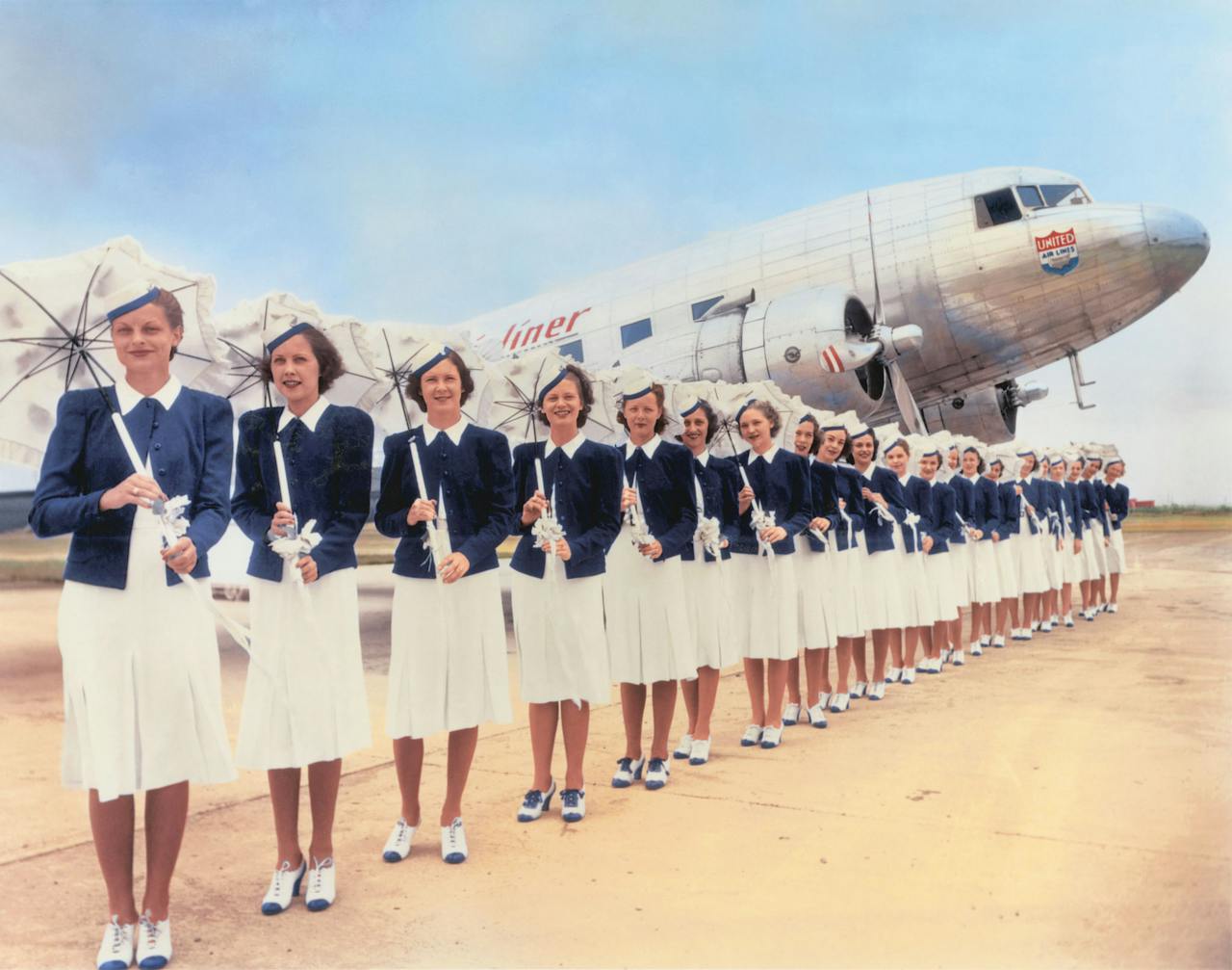 Stewardessen van United Airlines droegen in de jaren dertig een tweekleurig uniform, inclusief hoedje en minihakken.