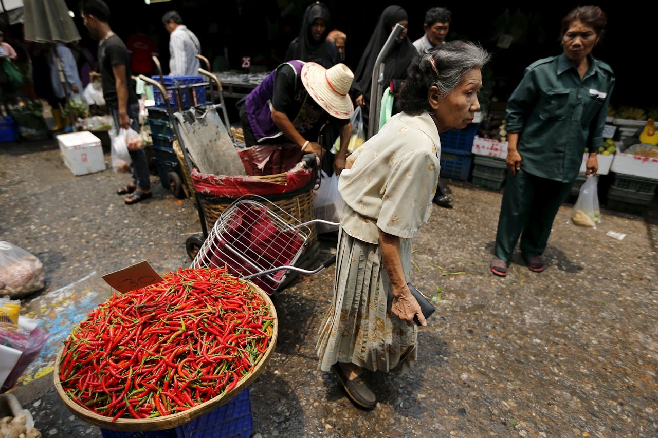 Een inwoonster uit Bangkok doet haar inkopen op de markt. (Foto: Reuters)