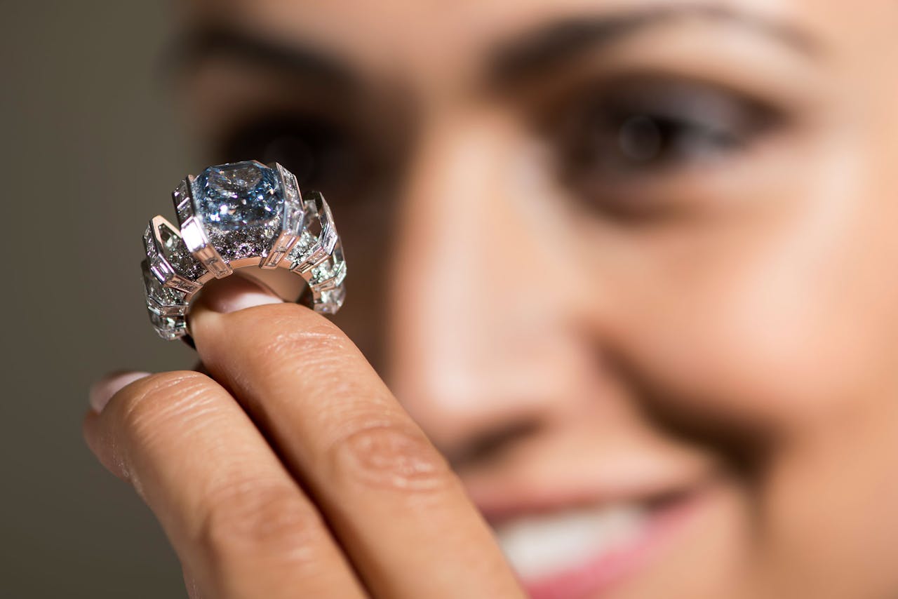 Een medewerker van Sotheby's toont in Genève een ring met de 'Sky Blue Diamond', een diamant met een gewicht van 8,01 karaat. Het juweel gaat volgende week woensdag onder de hamer. Verwachte opbrengst: $ 15 à 25 mln. (Foto: Jean-Christophe Bott/Keystone/AP)