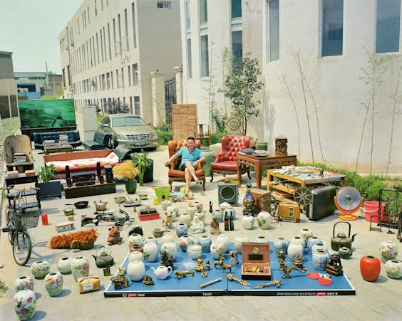 Foto van Huang Qingjun uit zijn serie ‘Family Stuff’. Hier is de 40-jarige kunstenaar Wenjue He vastgelegd bij zijn huis in Peking.