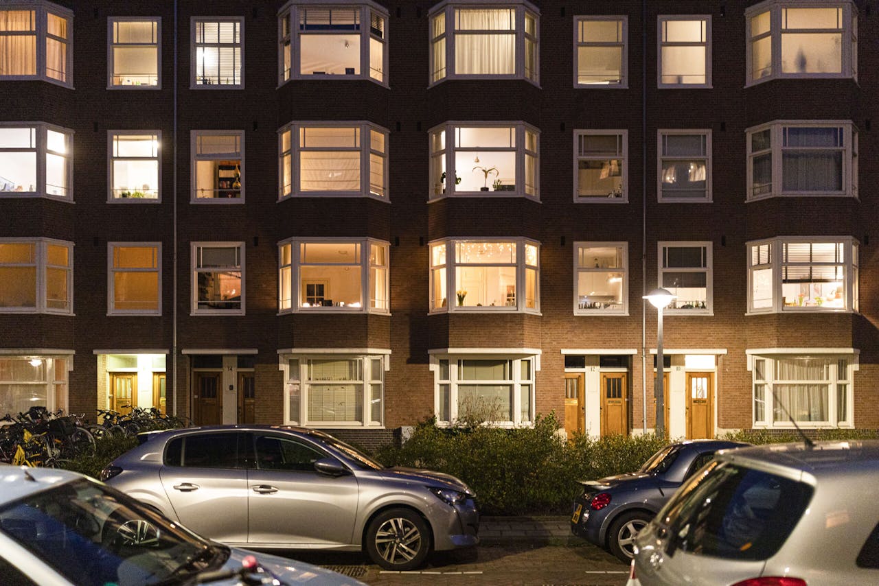 In de Rivierenbuurt in Amsterdam lichten de huiskamers om negen uur op. De meeste Nederlanders blijven 's avonds netjes binnen.