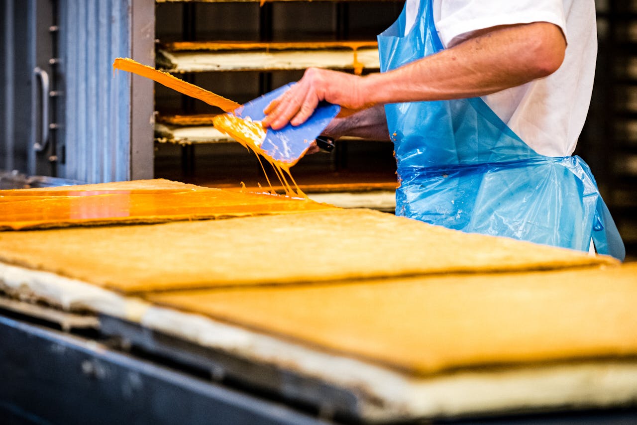 Productie van oranje tompoucen in de Hema-bakkerij in Helmond in aanloop naar Koningsdag 2021.