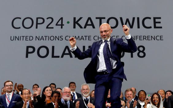 Michal Kurtyka, president van de klimaatconferentie in Katowice, maakt een vreugdesprong tijdens de afsluitende sessie van de top, op 15 december. Volgens hem kunnen de afgevaardigden trots zijn op 'duizend kleine stapjes vooruit.'
