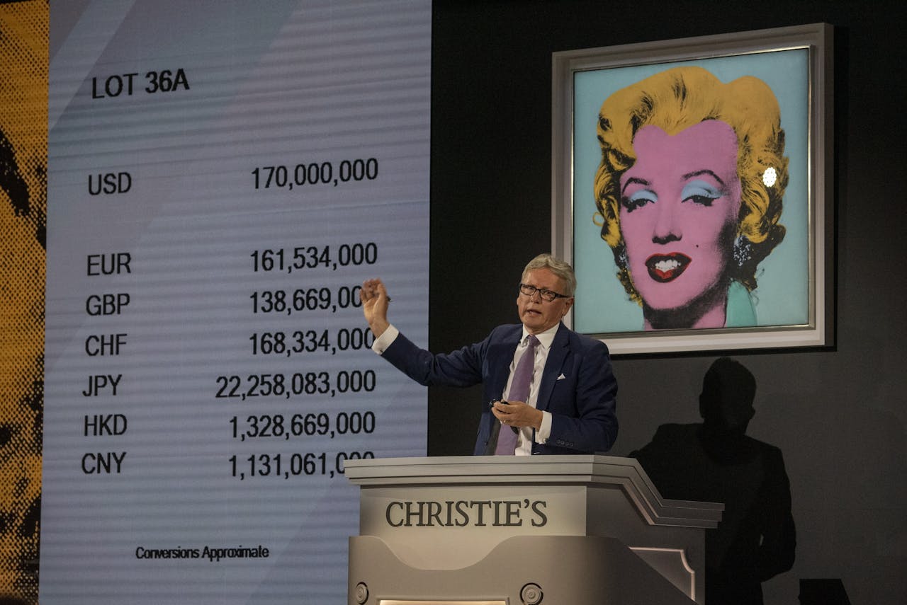 Een veilingmeester van Christie's in New York presenteert het eindbod van $195 mln voor de zeefdruk 'Shot Sage Blue Marilyn' van Andy Warhol.