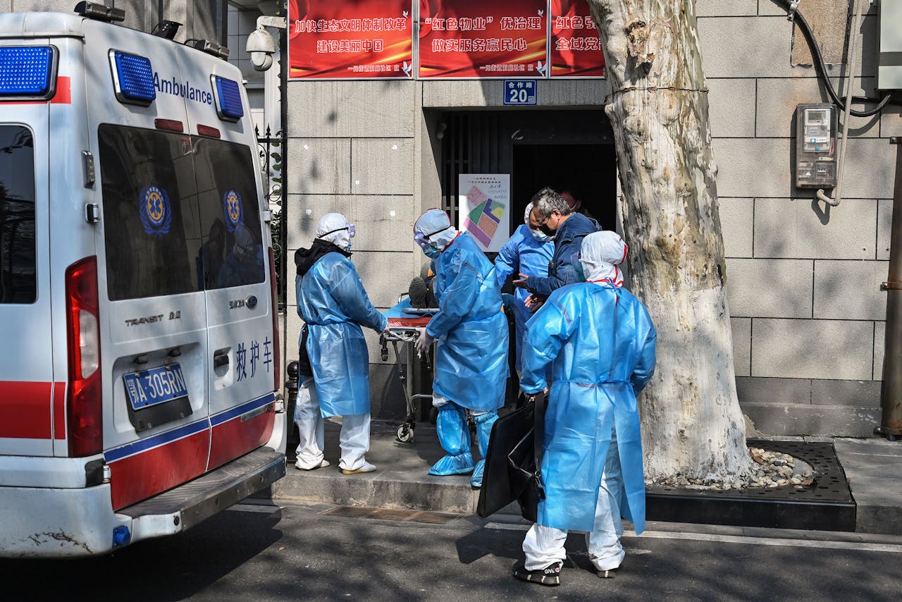 Ambulancepersoneel haalt een patiënt die mogelijk besmet is met het coronavirus uit zijn woning in het Chinese Wuhan.