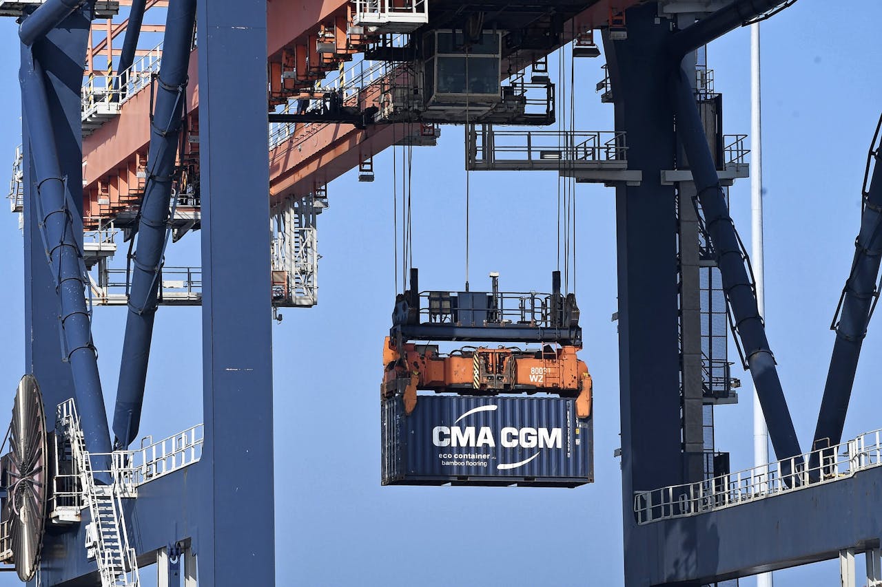 Een CMA CGM-container wordt uit een schip geladen op de Maasvlakte. Rederijen als CMA CGM en Maersk willen opstomen in de logistieke keten, niet alleen zee- maar ook luchtvervoer van vracht.