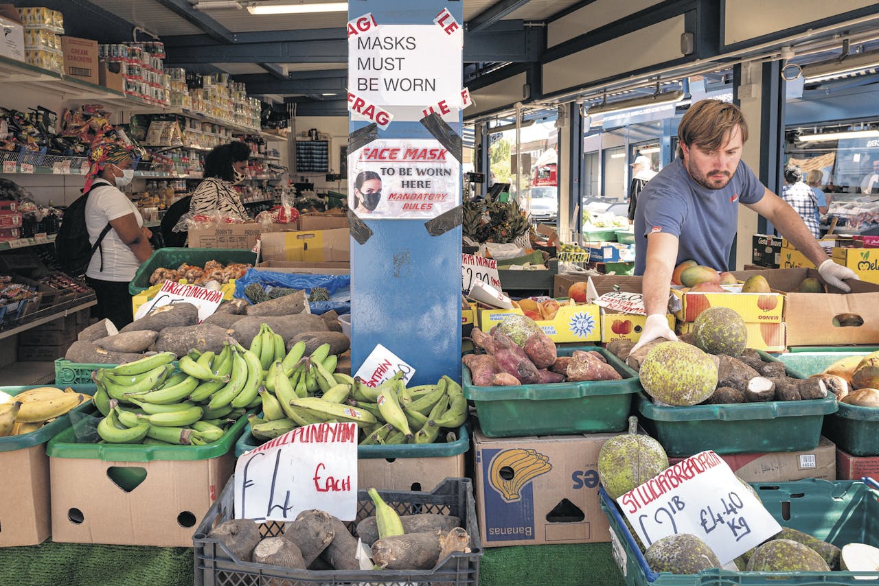 Hall’s Greengrocers aan Tottenham High Road in Noord-Londen. In Engeland zijn mondkapjes nu verplicht in het ov en publieke binnenruimten zoals stations, banken, winkels en supermarkten. Personeel is vrijgesteld van de mondkapjesplicht.