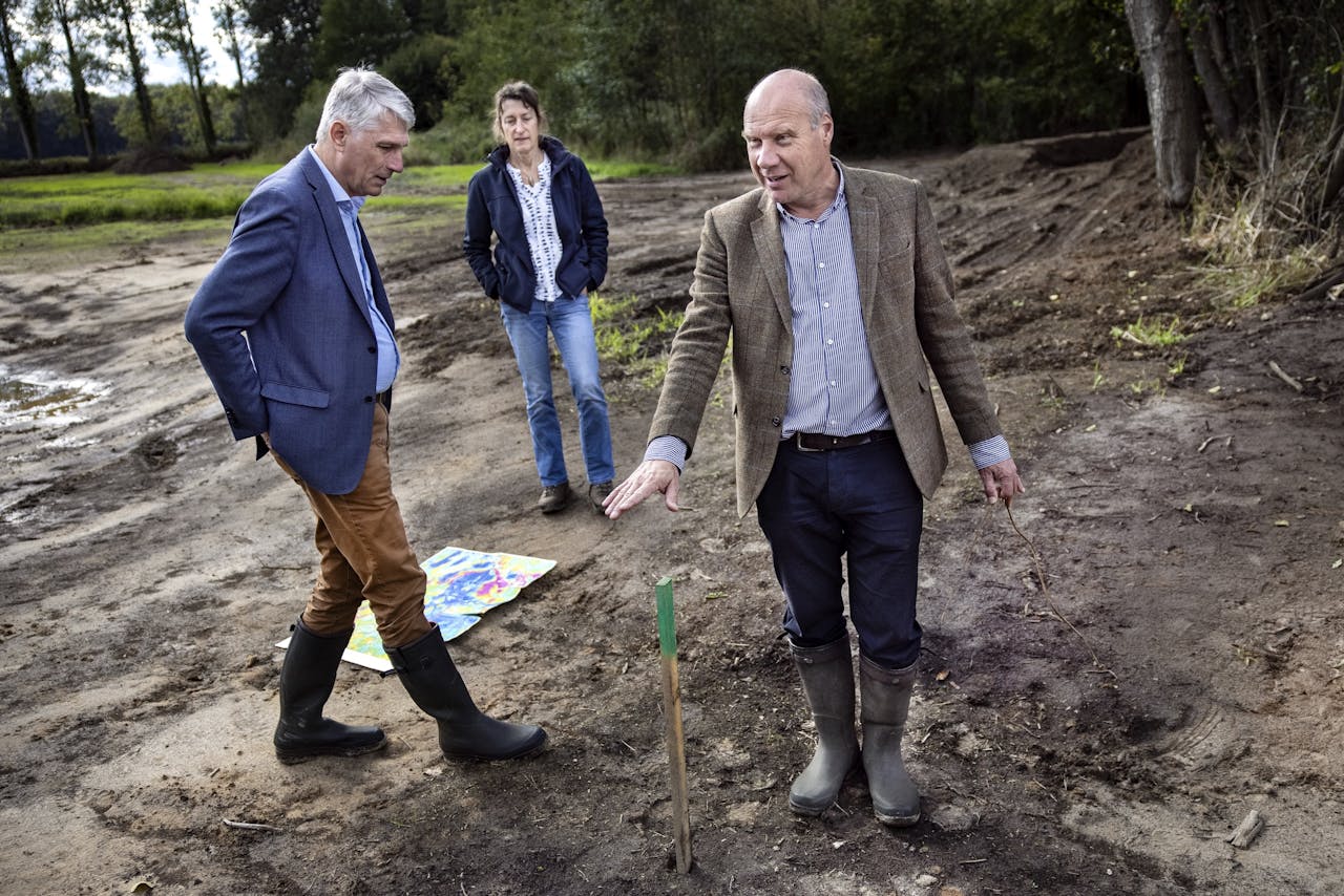 Dijkgraaf Hein Pieper van Waterschap Rijn en IJssel (l), omgevingsmanager Louisa Remesal en rentmeester Eelco Schurer lopen door het net afgegraven toekomstige beekdal van de Baakse Beek.